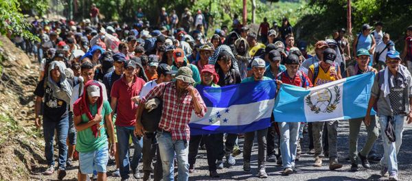 Honduran migrants take part in a new caravan heading to the US with Honduran and Guatemalan national flags in Quezaltepeque, Chiquimula, Guatemala on October 22, 2018 Honduran migrants take part in a new caravan heading to the US with Honduran and Guatemalan national flags in Quezaltepeque, Chiquimula, Guatemala on October 22, 2018 - Sputnik International