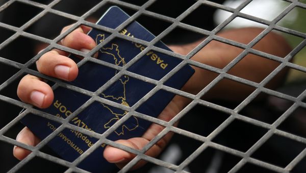 A man from El Salvador holds his passport in the back of a U.S. border patrol vehicle after he is apprehended for illegally crossing into the United States from Mexico in La Joya, Texas, U.S., October 17, 2018 - Sputnik International