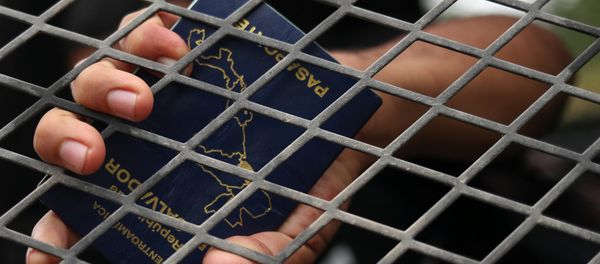 A man from El Salvador holds his passport in the back of a U.S. border patrol vehicle after he is apprehended for illegally crossing into the United States from Mexico in La Joya, Texas, U.S., October 17, 2018 A man from El Salvador holds his passport in the back of a U.S. border patrol vehicle after he is apprehended for illegally crossing into the United States from Mexico in La Joya, Texas, U.S., October 17, 2018 - Sputnik International
