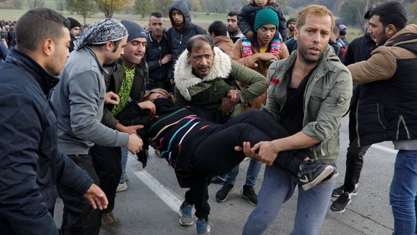 Migrants carry a woman who was injured during minor clashes with Croatian riot police at Maljevac border crossing between Bosnia and Croatia near Velika Kladusa, Bosnia, October 24, 2018 Migrants carry a woman who was injured during minor clashes with Croatian riot police at Maljevac border crossing between Bosnia and Croatia near Velika Kladusa, Bosnia, October 24, 2018 - Sputnik International