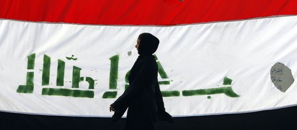 An Iraqi woman walks her national flag during a celebration marking the the departure of US troops from Iraq in Baghdad's Adhamiyah neighbourhood. File photo - Sputnik International