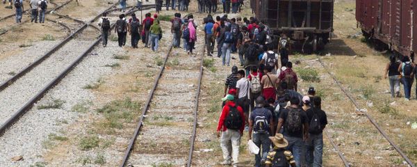 Immigrants walk along the rail tracks after getting off a train during their journey toward the US-Mexico border in Ixtepec, southern Mexico Immigrants walk along the rail tracks after getting off a train during their journey toward the US-Mexico border in Ixtepec, southern Mexico - Sputnik International