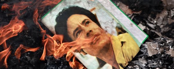 A portrait of Muammar Gaddafi burning in a fire. A portrait of Muammar Gaddafi burning in a fire. - Sputnik International