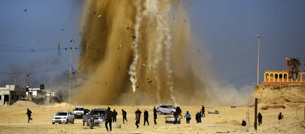 Palestinians run for cover as smoke rises following an Israeli air strike on a Hamas post, in the northern Gaza Strip on February 6, 2017 Palestinians run for cover as smoke rises following an Israeli air strike on a Hamas post, in the northern Gaza Strip on February 6, 2017 - Sputnik International