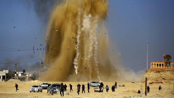 Palestinians run for cover as smoke rises following an Israeli air strike on a Hamas post, in the northern Gaza Strip on February 6, 2017 - Sputnik International