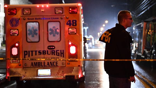 An FBI agent stands behind a police cordon and an ambulance outside the Tree of Life Synagogue (L) after a shooting there left 11 people dead in the Squirrel Hill neighborhood of Pittsburgh on October 27, 2018. An FBI agent stands behind a police cordon and an ambulance outside the Tree of Life Synagogue (L) after a shooting there left 11 people dead in the Squirrel Hill neighborhood of Pittsburgh on October 27, 2018. - Sputnik International