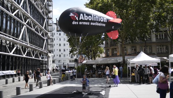 A woman sits underneath a balloon shaped like a nuclear bomb outside the Centre Georges Pompidou in Paris on August 7, 2017, during an action and four-day hunger strike organised by the network Sortir du nucleaire and the collective Abolition des armes nucleaires - Maison de Vigilance to call for the disarmament of nuclear weapons and for France to sign a UN treaty to ban nuclear weapons A woman sits underneath a balloon shaped like a nuclear bomb outside the Centre Georges Pompidou in Paris on August 7, 2017, during an action and four-day hunger strike organised by the network Sortir du nucleaire and the collective Abolition des armes nucleaires - Maison de Vigilance to call for the disarmament of nuclear weapons and for France to sign a UN treaty to ban nuclear weapons - Sputnik International
