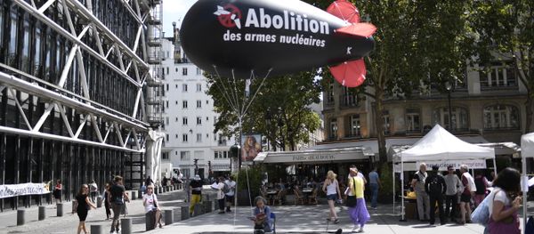 A woman sits underneath a balloon shaped like a nuclear bomb outside the Centre Georges Pompidou in Paris on August 7, 2017, during an action and four-day hunger strike organised by the network Sortir du nucleaire and the collective Abolition des armes nucleaires - Maison de Vigilance to call for the disarmament of nuclear weapons and for France to sign a UN treaty to ban nuclear weapons - Sputnik International