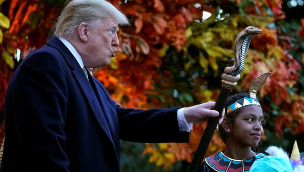 U.S. President Donald Trump waves the staff of a child dressed as a pharaoh as he hands out Halloween candy to trick-or-treaters at the White House in Washington, U.S., October 28, 2018 U.S. President Donald Trump waves the staff of a child dressed as a pharaoh as he hands out Halloween candy to trick-or-treaters at the White House in Washington, U.S., October 28, 2018 - Sputnik International