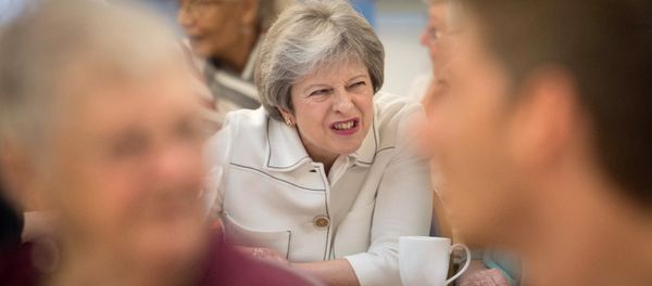 Britain's Prime Minister Theresa May reacts as she talks with people attending a social group in Vauxhall, south London, on October 15, 2018, where she launched the government's loneliness strategy Britain's Prime Minister Theresa May reacts as she talks with people attending a social group in Vauxhall, south London, on October 15, 2018, where she launched the government's loneliness strategy - Sputnik International