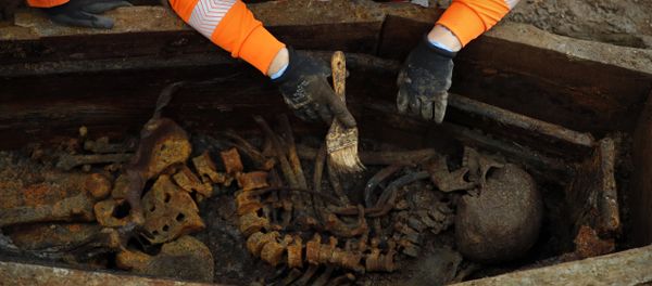 A field archaelogist uses a brush on a skeleton in an open coffin during the excavation of a late 18th to mid 19th century cemetery under St James Gardens near Euston train station in London on November 1, 2018 as part of the HS2 high-speed rail project. A field archaelogist uses a brush on a skeleton in an open coffin during the excavation of a late 18th to mid 19th century cemetery under St James Gardens near Euston train station in London on November 1, 2018 as part of the HS2 high-speed rail project. - Sputnik International