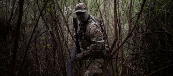 An agent with the U.S. Border Patrol Tactical Unit (BORTAC) searches a pathway near the Rio Grand river used by families who illegally cross into the United States from Mexico in Fronton, Texas, U.S., October 18, 2018. Picture taken October 18, 2018 - Sputnik International