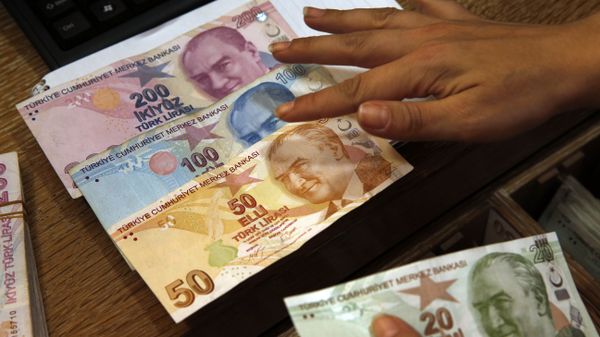 In this Wednesday, Aug. 15, 2018, file photo a worker at a currency exchange shop exhibits Turkish lira banknotes bearing pictures of modern Turkey's founder Mustafa Kemal Ataturk, in Istanbul.(file photo) - Sputnik International