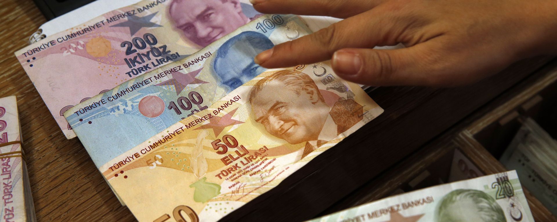 In this Wednesday, Aug. 15, 2018, file photo a worker at a currency exchange shop exhibits Turkish lira banknotes bearing pictures of modern Turkey's founder Mustafa Kemal Ataturk, in Istanbul.(file photo) - Sputnik International, 1920, 05.08.2024