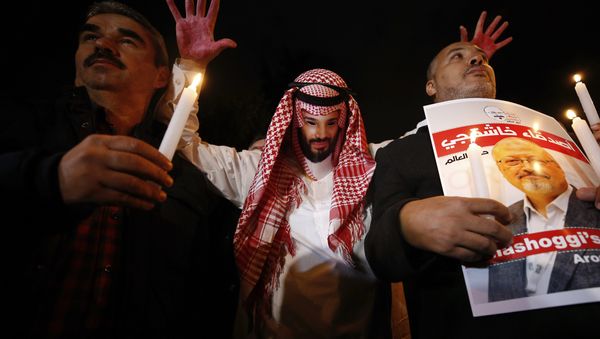 An activist, wearing a mask depicting Saudi Crown Prince Mohammed bin Salman, holds up his hands, painted with fake blood as he protests the killing of Saudi journalist Jamal Khashoggi, during a candlelight vigil outside Saudi Arabia's consulate in Istanbul, Thursday, Oct. 25, 2018 An activist, wearing a mask depicting Saudi Crown Prince Mohammed bin Salman, holds up his hands, painted with fake blood as he protests the killing of Saudi journalist Jamal Khashoggi, during a candlelight vigil outside Saudi Arabia's consulate in Istanbul, Thursday, Oct. 25, 2018 - Sputnik International