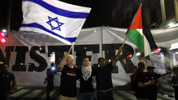 Arab Israelis and their supporters carry a Palestinian (R) and an Israeli flag during a demonstration Arab Israelis and their supporters carry a Palestinian (R) and an Israeli flag during a demonstration - Sputnik International