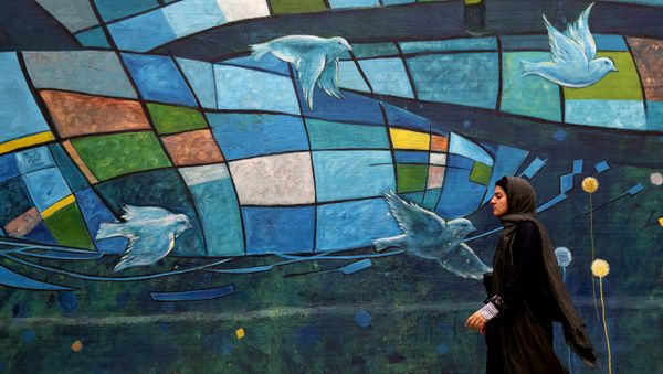 An Iranian woman walks past colourful walls in the capital Tehran on November 5, 2018 An Iranian woman walks past colourful walls in the capital Tehran on November 5, 2018 - Sputnik International