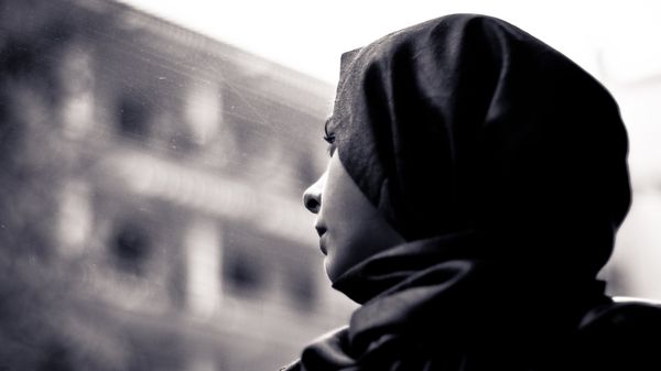 A woman wearing a hijab looks through the window - Sputnik International