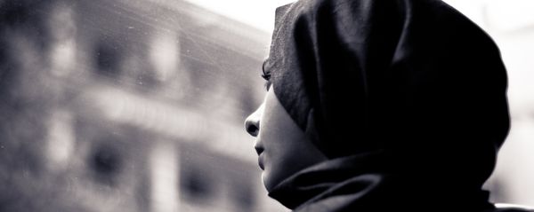 A woman wearing a hijab looks through the window A woman wearing a hijab looks through the window - Sputnik International