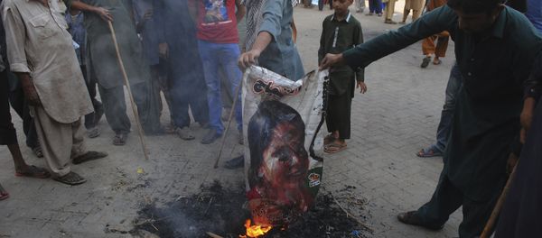 Pakistani protesters burn a poster image of Christian woman Asia Bibi, who has spent eight-years on death row accused of blasphemy and acquitted by a Supreme Court, in Hyderabad, Pakistan, Thursday, Nov. 1, 2018 - Sputnik International