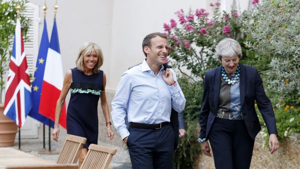 French President Emmanuel Macron and his wife Brigitte Macron, left, walk with British Prime Minister Theresa May, right, and her husband Philip May, hidden, prior to a diner at the Fort de Bregancon in Bornes-les-Mimosas, southern France, Friday Aug. 3, 2018 French President Emmanuel Macron and his wife Brigitte Macron, left, walk with British Prime Minister Theresa May, right, and her husband Philip May, hidden, prior to a diner at the Fort de Bregancon in Bornes-les-Mimosas, southern France, Friday Aug. 3, 2018 - Sputnik International