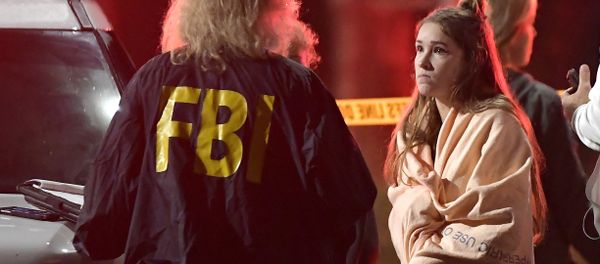 An FBI agent talks to a potential witness as they stand near the scene Thursday, Nov. 8, 2018, in Thousand Oaks, Calif. where a gunman opened fire Wednesday inside a country dance bar crowded with hundreds of people on college night, wounding 11 people including a deputy who rushed to the scene - Sputnik International