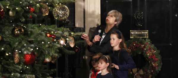 Britain's Prime Minister Theresa May stands with children as she switches on the Christmas tree lights at 10 Downing Street in London, Wednesday, Dec. 6, 2017. - Sputnik International