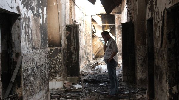 In this Friday, Oct. 16, 2015 photo, an employee of Doctors Without Borders walks inside the charred remains of their hospital after it was hit by a U.S. airstrike in Kunduz, Afghanistan - Sputnik International