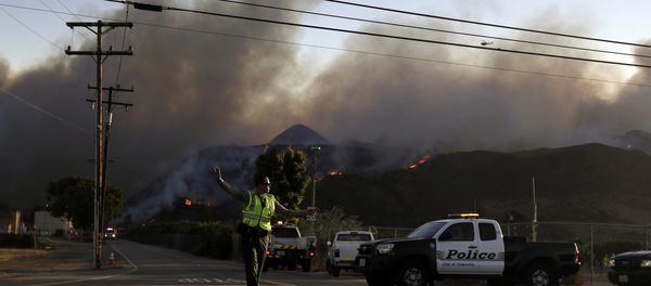 A police officer mans a checkpoint in front of an advancing wildfire Thursday, Nov. 8, 2018, near Newbury Park, Calif. The Ventura County Fire Department has also ordered evacuation of some communities in the path of the fire, which erupted a few miles from the site of Wednesday night's deadly mass shooting at a Thousand Oaks bar. - Sputnik International