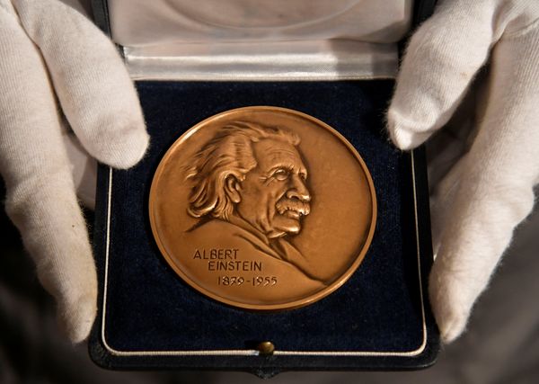 Fine-art handler Tom Richardson displays The Albert Einstein Award given to the British theoretical physicist Stephen Hawking ahead of an auction of items from Hawkings' personal estate at Christie's in London, Britain October 30, 2018.  - Sputnik International