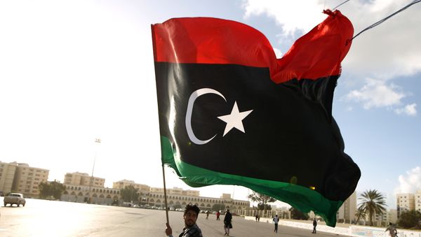 A Libyan man waves a national flag - Sputnik International