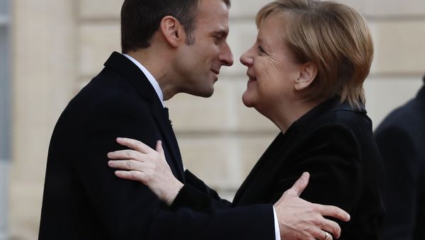French President Emmanuel Macron hugs German Chancellor Angela Merkel in the courtyard of the Elysee Palace. File photo - Sputnik International