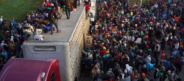 Migrants, part of a caravan of thousands traveling from Central America en route to the United States, try to catch a ride on a truck, in Irapuato, Mexico November 12, 2018 Migrants, part of a caravan of thousands traveling from Central America en route to the United States, try to catch a ride on a truck, in Irapuato, Mexico November 12, 2018 - Sputnik International