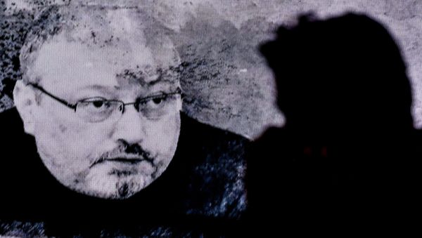 A man passes in front of a screen showing Jamal Khashoggi during a commemoration event of Khashoggi's supporters on November 11, 2018 in Istanbul - Sputnik International