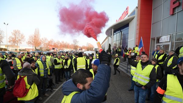 A demonstrators holds a flare during a demonstration of Yellow Vests (Gilets jaunes) against the rising of the fuel and oil prices on November 17, 2018 in Vendenheim, eastern France. - Sputnik International
