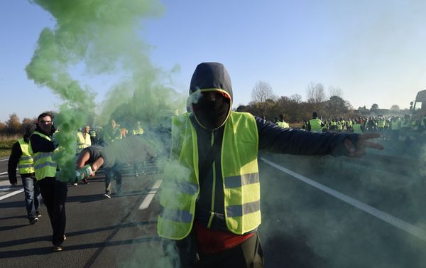A man holds a flare as demonstrators wearing yellow vests (Gilets jaunes) protest against the rising of the fuel and oil prices on November 17, 2018 in Haulchien near Valenciennes, northern France. A man holds a flare as demonstrators wearing yellow vests (Gilets jaunes) protest against the rising of the fuel and oil prices on November 17, 2018 in Haulchien near Valenciennes, northern France. - Sputnik International