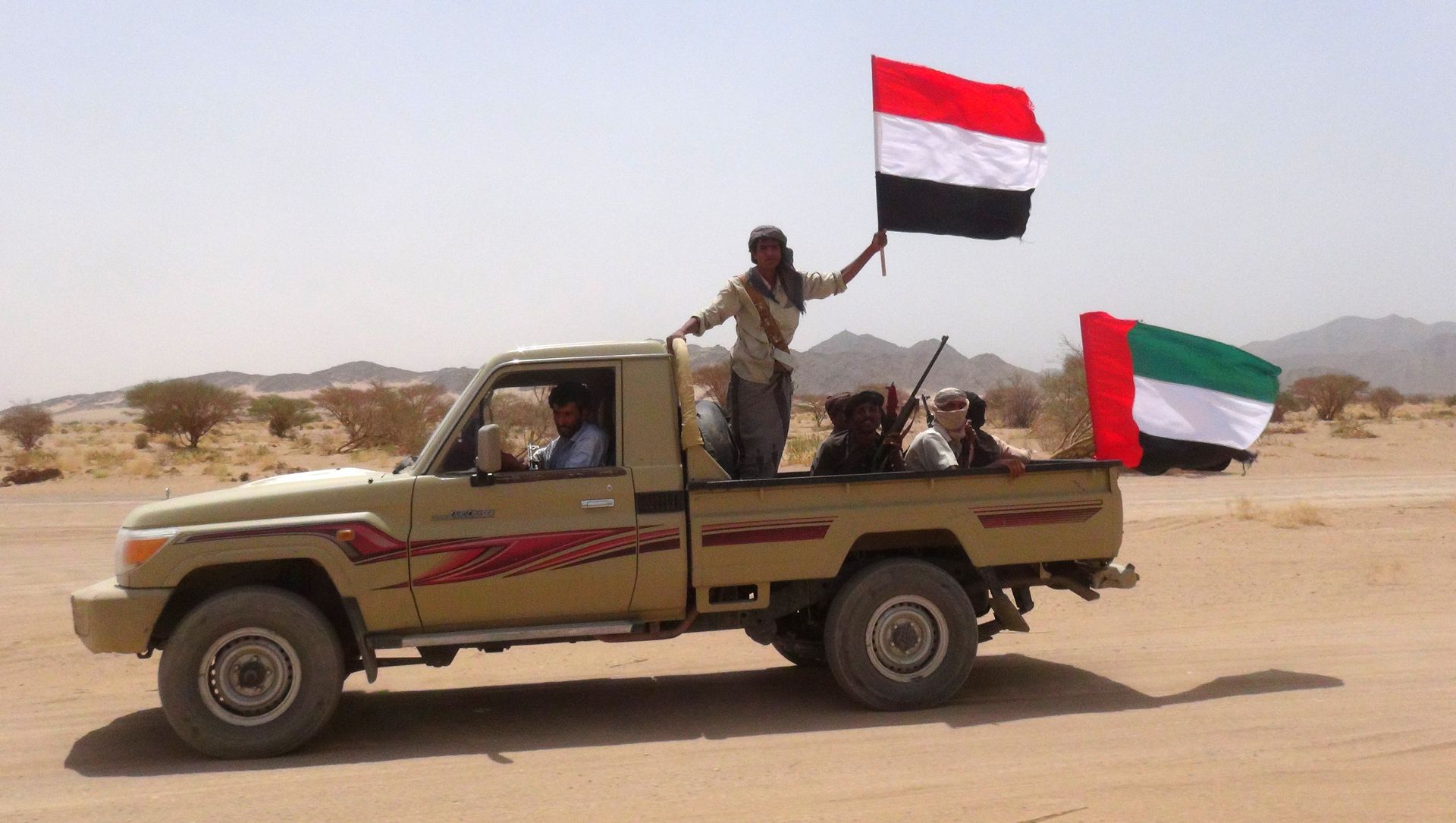 Yemeni tribesmen from the Popular Resistance Committees, supporting forces loyal to Yemen's Saudi-backed fugitive President Abedrabbo Mansour Hadi, hold the Emirati (R) and Yemeni flag as they drive in Marib province, east of the Yemeni capital, Sanaa, on September 20, 2015 Yemeni tribesmen from the Popular Resistance Committees, supporting forces loyal to Yemen's Saudi-backed fugitive President Abedrabbo Mansour Hadi, hold the Emirati (R) and Yemeni flag as they drive in Marib province, east of the Yemeni capital, Sanaa, on September 20, 2015 - Sputnik International, 1920, 10.03.2021