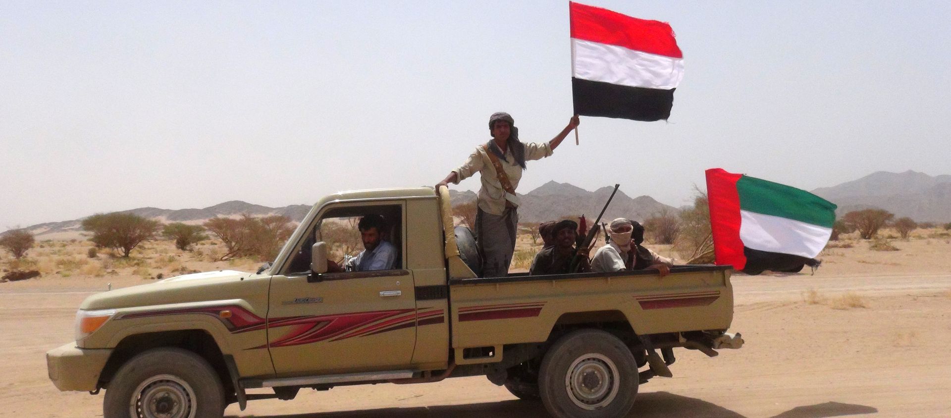 Yemeni tribesmen from the Popular Resistance Committees, supporting forces loyal to Yemen's Saudi-backed fugitive President Abedrabbo Mansour Hadi, hold the Emirati (R) and Yemeni flag as they drive in Marib province, east of the Yemeni capital, Sanaa, on September 20, 2015 Yemeni tribesmen from the Popular Resistance Committees, supporting forces loyal to Yemen's Saudi-backed fugitive President Abedrabbo Mansour Hadi, hold the Emirati (R) and Yemeni flag as they drive in Marib province, east of the Yemeni capital, Sanaa, on September 20, 2015 - Sputnik International, 1920, 10.03.2021