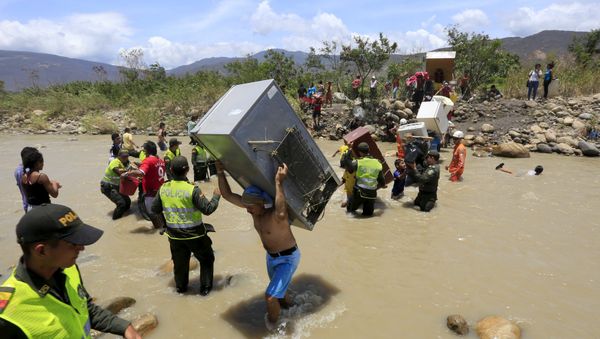 A man carries a refrigerator while crossing the Tachira river border with Venezuela into Colombia, near Villa del Rosario village August 25, 2015 A man carries a refrigerator while crossing the Tachira river border with Venezuela into Colombia, near Villa del Rosario village August 25, 2015 - Sputnik International