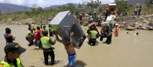 A man carries a refrigerator while crossing the Tachira river border with Venezuela into Colombia, near Villa del Rosario village August 25, 2015 A man carries a refrigerator while crossing the Tachira river border with Venezuela into Colombia, near Villa del Rosario village August 25, 2015 - Sputnik International