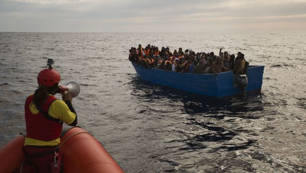 Migrants and refugees are assisted by members of the Spanish NGO Proactiva Open Arms, as they crowd aboard a boat sailing out of control in the Mediterranean Sea about 21 miles north of Sabratha, Libya, on Friday, Feb. 3, 2017. European Union leaders are poised to take a big step on Friday in closing off the illegal migration routes from Libya across the central Mediterranean, where thousands have died trying to reach the EU, the EU foreign affairs chief Federica Mogherini said. - Sputnik International