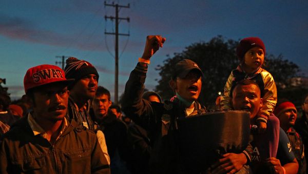 Migrants, part of a caravan of thousands from Central America trying to reach the United States, stand outside of the El Chaparral port of entry border crossing between Mexico and the United States, in Tijuana, Mexico, November 22, 2018 - Sputnik International