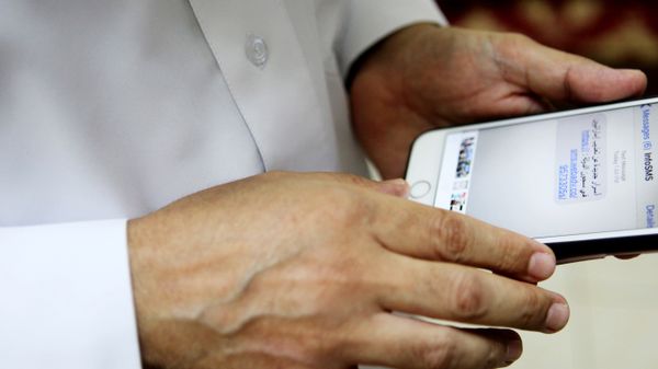 Human rights activist Ahmed Mansoor shows Associated Press journalists a screenshot of a spoof text message he received in Ajman, United Arab Emirates, on Thursday, Aug. 25, 2016 - Sputnik International