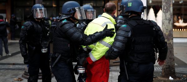 French riot police apprehend a protester wearing a yellow vest, a symbol of a French drivers' protest against higher fuel prices, during clashes on the Champs-Elysees in Paris, France, November 24, 2018. Picture taken November 24, 2018 - Sputnik International