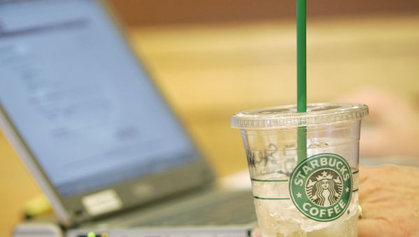 An iced drink sits next to a laptop computer in use Monday, Feb. 11, 2008, at a Starbucks Corp. store near the University of Washington in Seattle. Starbucks and AT&T Inc. will start offering a mix of free and paid wireless Internet service in most of the international coffee retailer's U.S. shops, beginning this spring. - Sputnik International