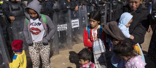 Migrants stand near Mexican police at the Mexico-U.S. border in Tijuana, Mexico, Sunday, Nov. 25, 2018, as they try to reach the US. - Sputnik International