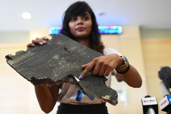 Grace Subathirai Nathan (R), daughter of Malaysian Airlines flight MH370 passenger Anne Daisy, shows a piece of debris believed to be from flight MH370 during a press conference in Putrajaya on November 30, 2018 - Sputnik International