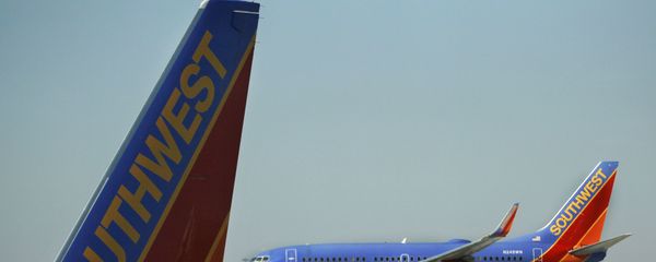 In this Feb. 9, 2012, a Southwest Airlines Boeing lands at Chicago's Midway Airport as another sits at a gate. Southwest Airlines Co. said Thursday, March 1, 2012, that it took a step toward combining its fleet with that of AirTran Airways as U.S. officials gave the airlines a single operating certificate - Sputnik International