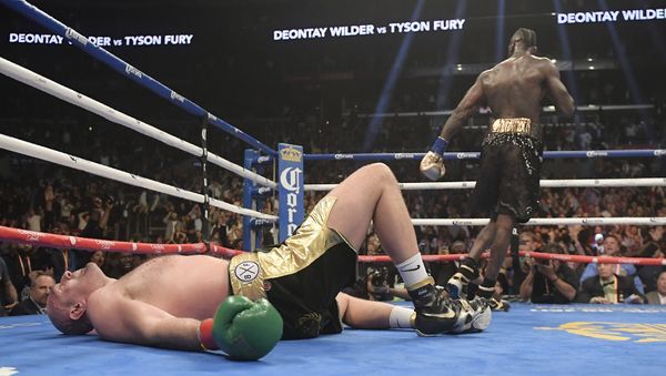 Tyson Fury lies prostrate on the canvas in the final round of Saturday's fight with Deontay Wilder in Los Angeles - Sputnik International