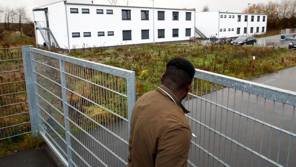 A man closes the garden gate of a refugee shelter where a 17-year-old girl was found dead in Sankt Augustin, near Bonn, Germany, December 3, 2018 - Sputnik International
